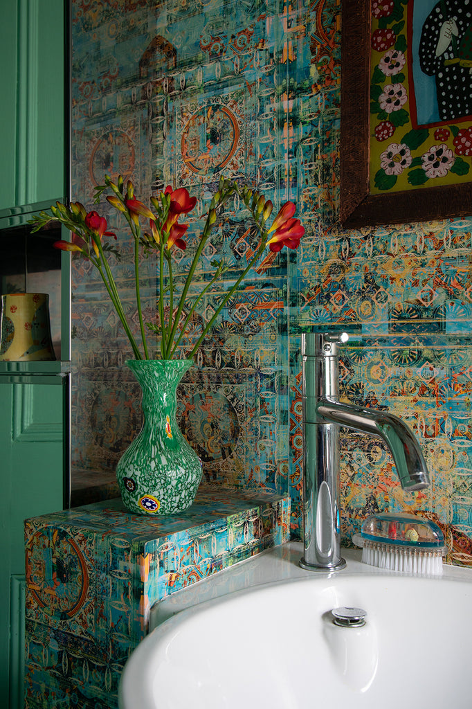 Blackpop Capriccio wallpaper covering a wall with a sink and decorative vase