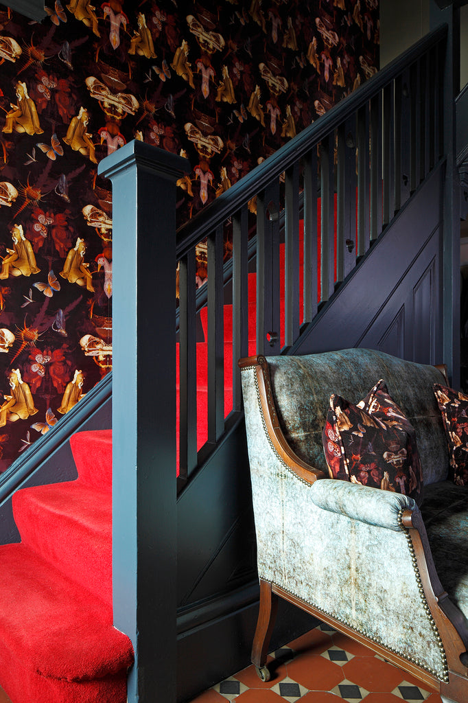 Grand Reader wallpaper in dramatic hallway with red carpet run and blue staircase. 