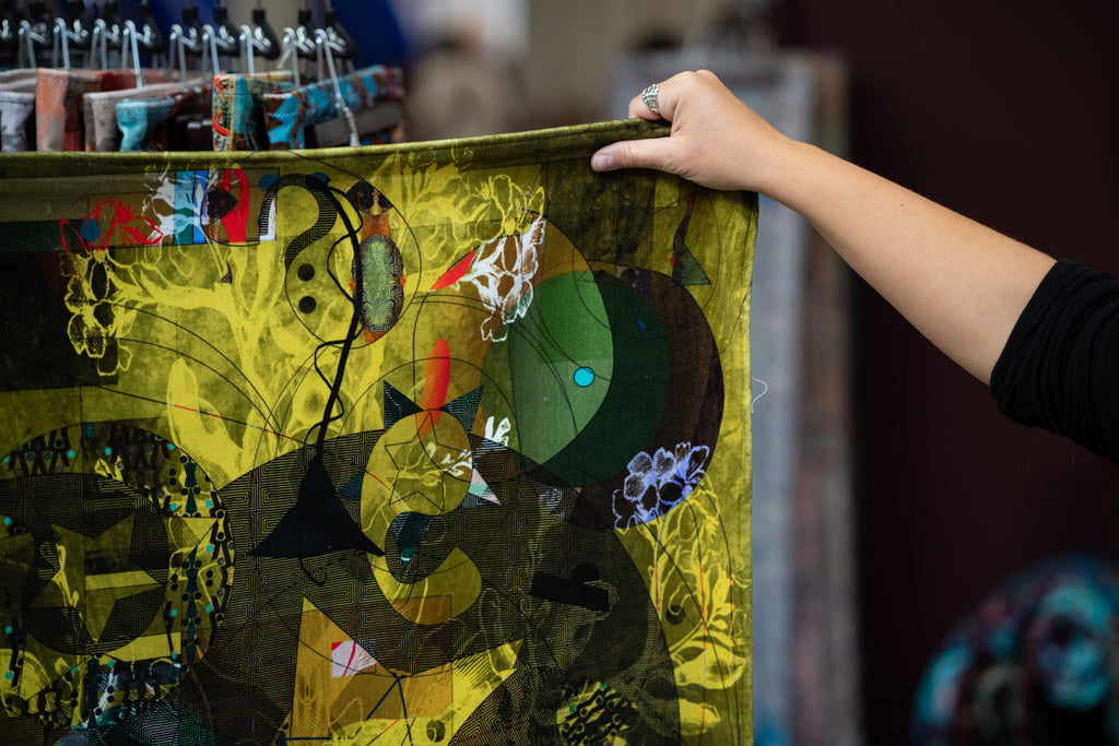 Designer holding Elektra fabric drop - bold velvet green, blue and pink abstract pop art elements 