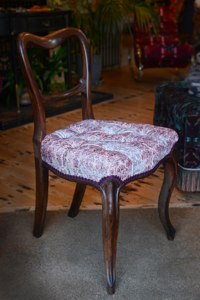 Side-angled view of antique chair upholstered in Chapelle Sunrise cotton velvet. 