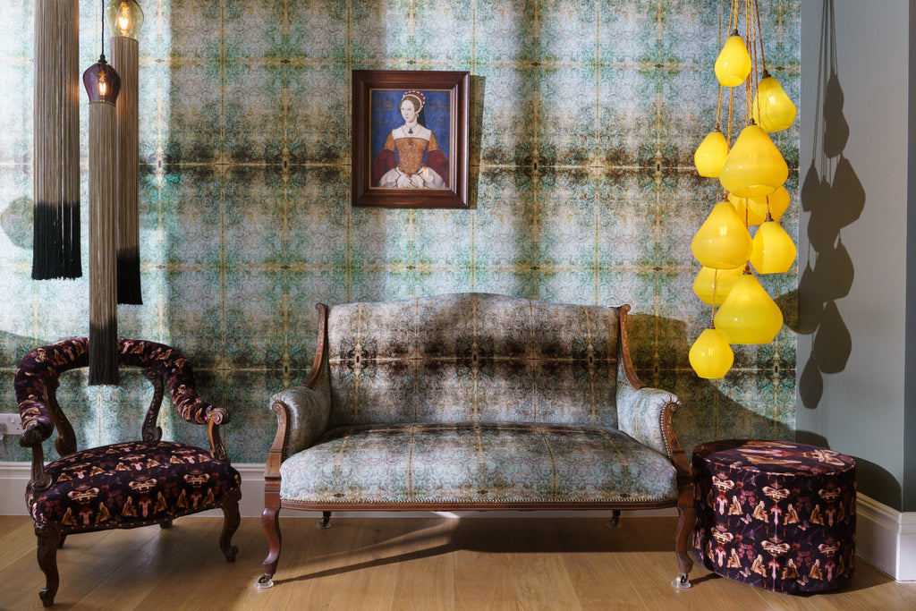Duprez velvet sofa and wallpaper in soft teal and brown, styled in a vintage room with Tudor portrait and bold lighting