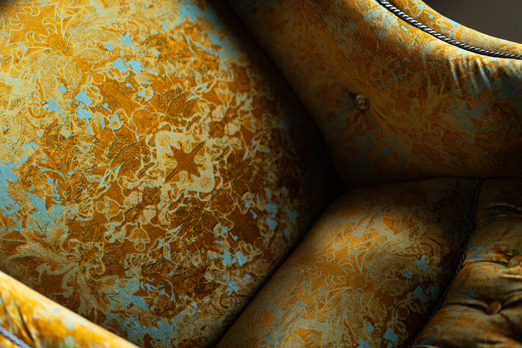 Close-up of Garbo velvet fabric with vintage damask detailed pattern in yellow ochres and blue. 