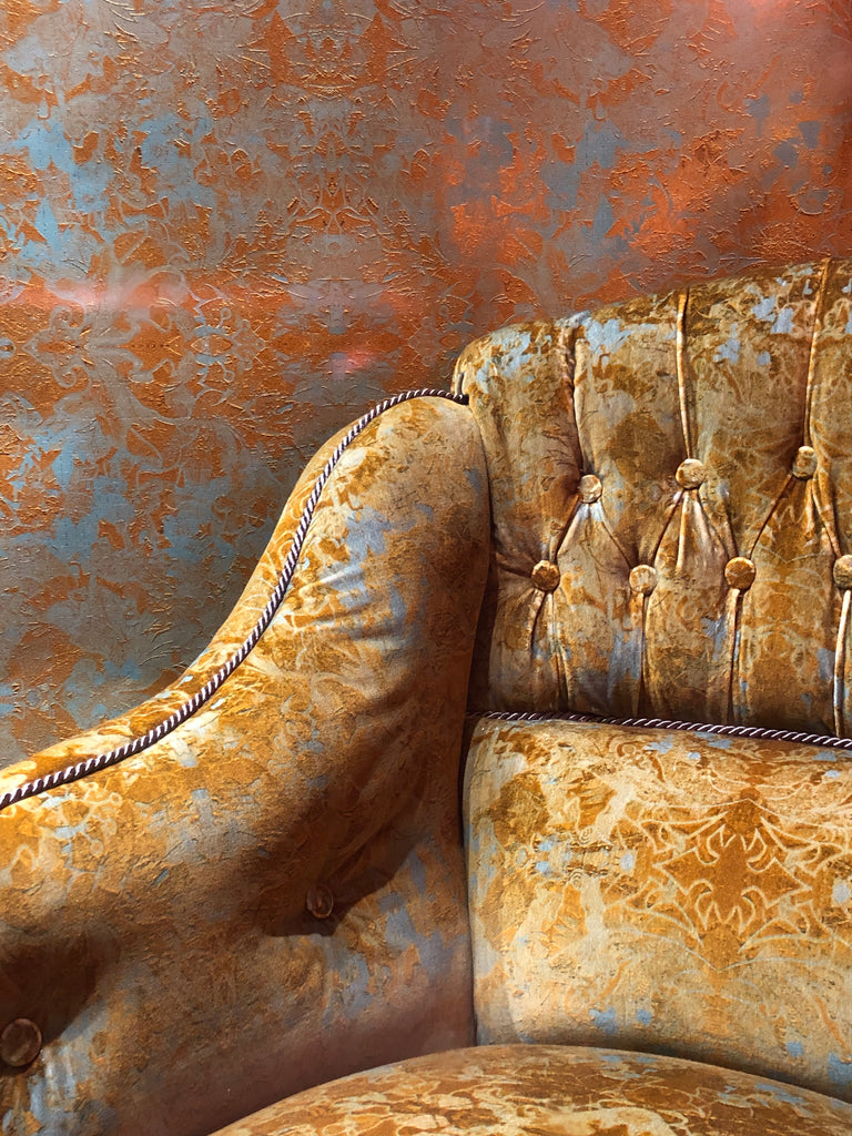 Close-up of a Garbo upholstered armchair featuring intricate modern damask patterns on luxury velvet.