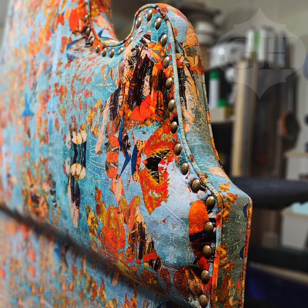 Close-up of ‘Mary’ upholstered headboard with abstract blue and orange patterns with hand studded details.