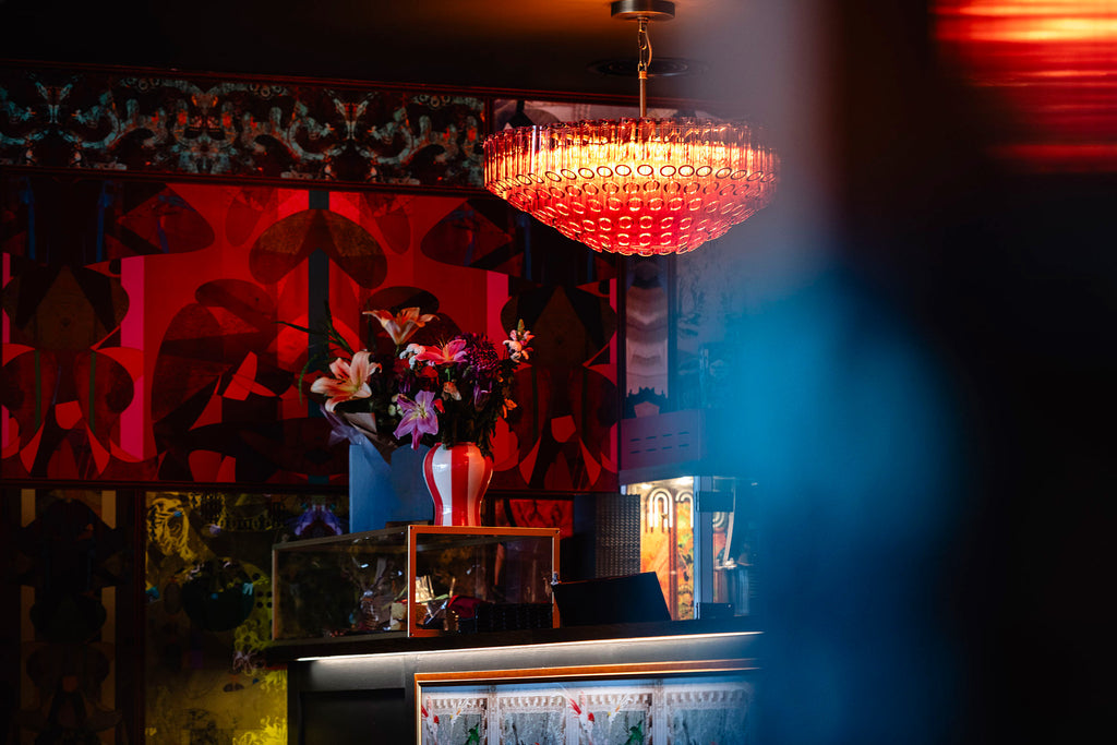 Stevie at the Ritz wallpaper styled in cinema bar with pink glass chandelier 