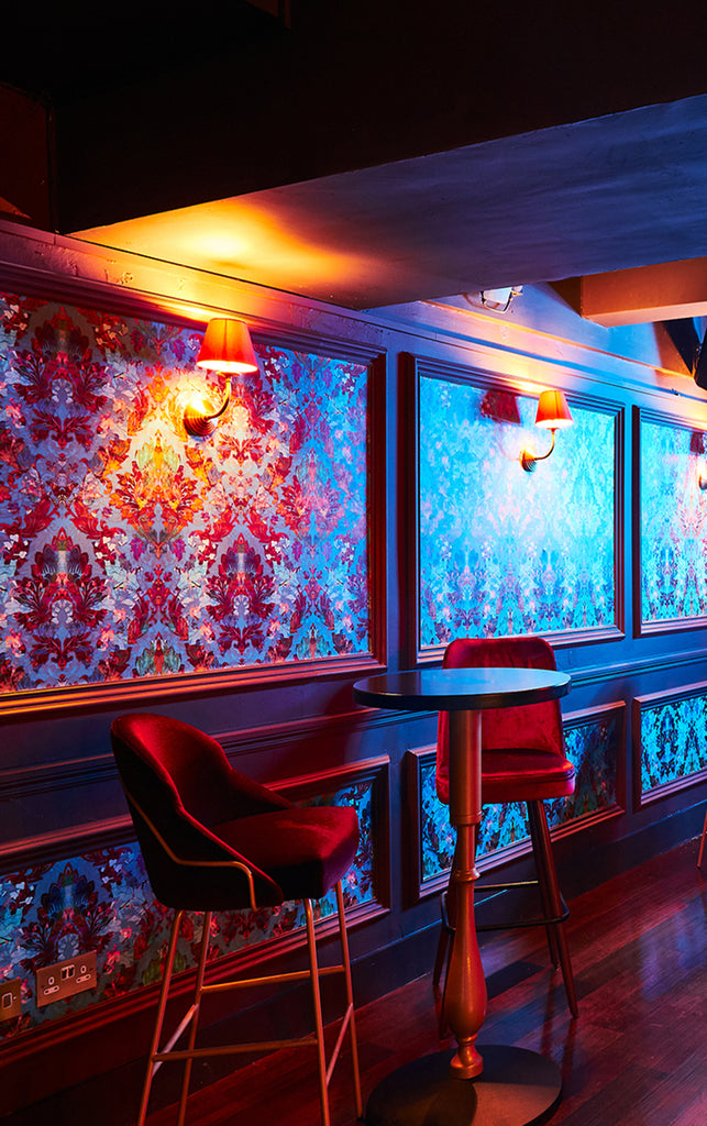 Orpheus wallpaper, Decorative interior with colorful wall art and red chairs