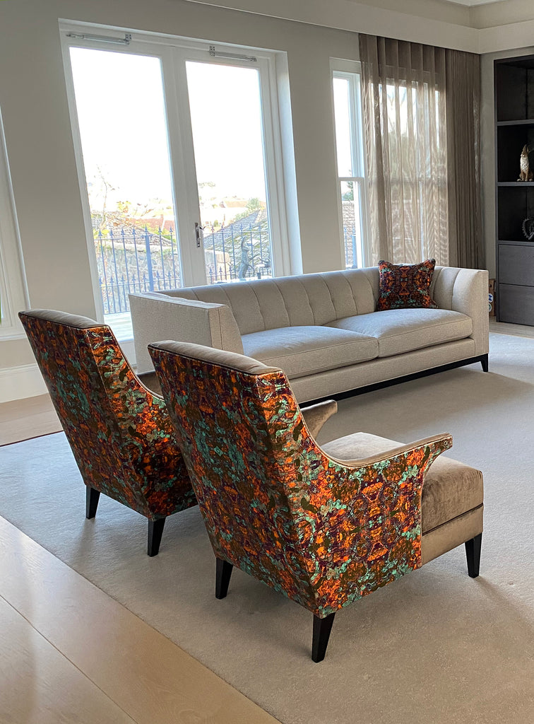 Grey armchairs upholstered on the back and sides in rosetta velvet fabric with details of green and orange abstract pattern 