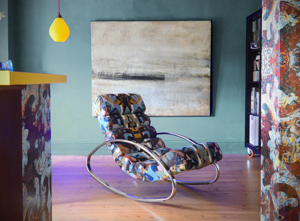 ’Stevie at the Diner’ wave chair in a room with abstract art and a lamp.