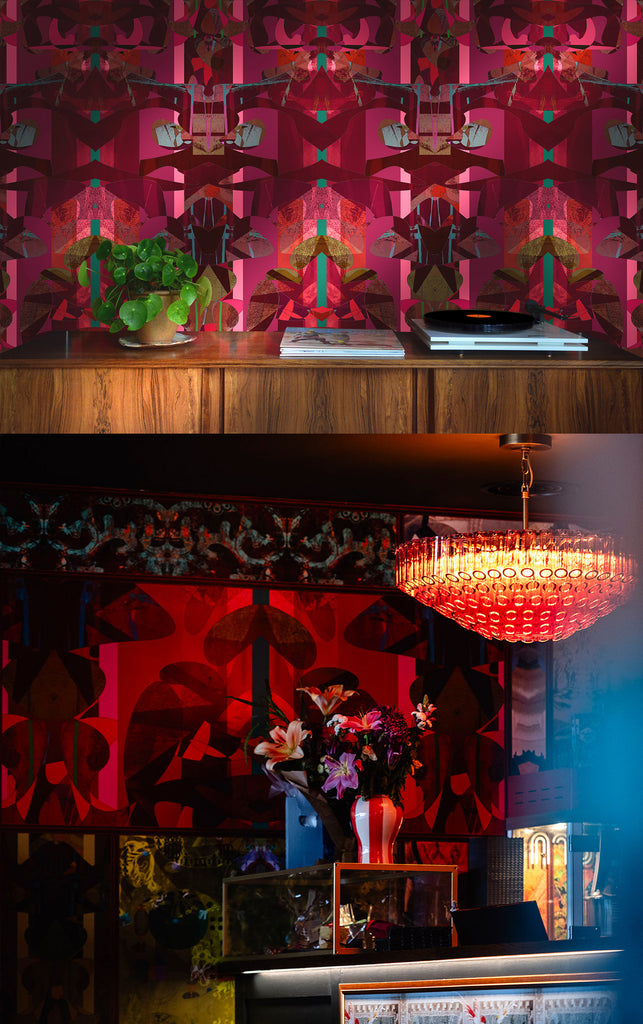 Decorative interior with a pink patterned wall, wooden shelf, and chandelier.