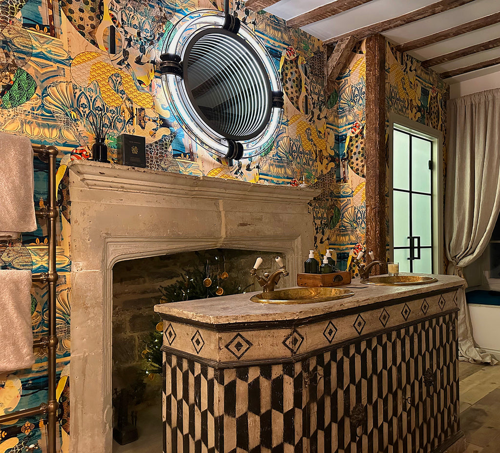 Walladawn featured wall in old manner bathroom with wooden beams and rustic gold sink. 