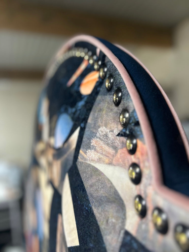 Close-up of ‘Labyrinth’ upholstered headboard with navy blue geometrics patterns, dusky pink piping and gold studs.