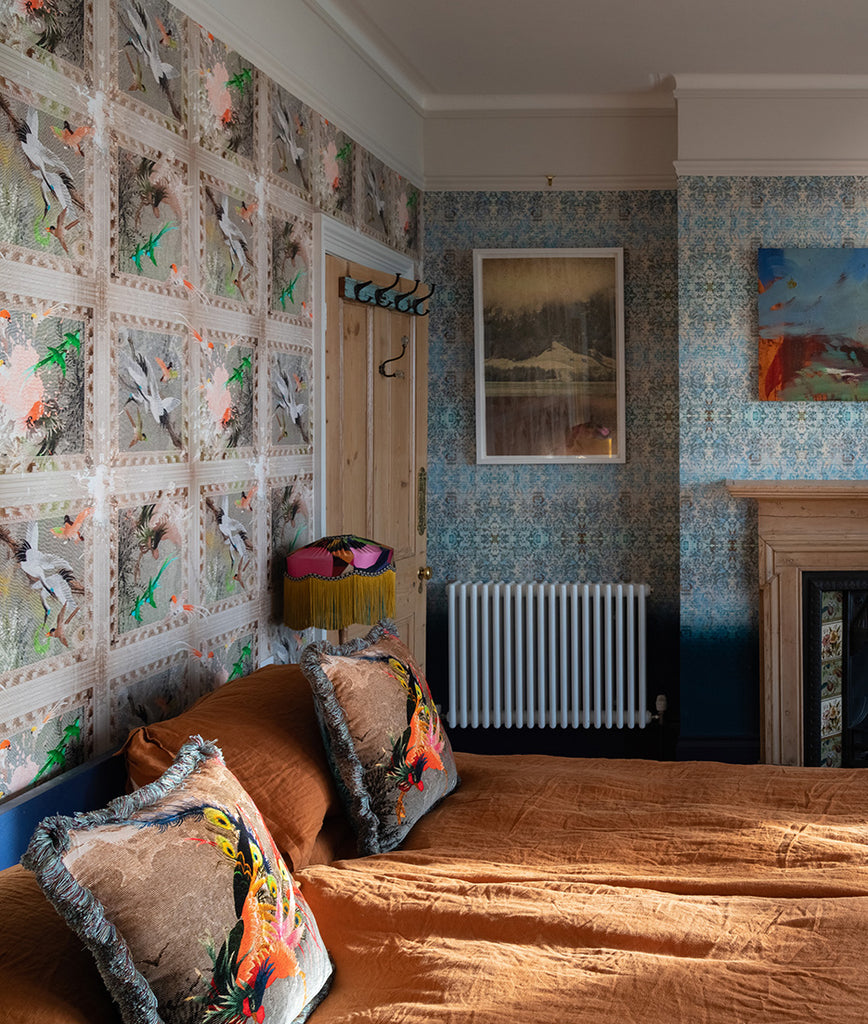 Paradise wallpaper with exotic birds and florals, creating dramatic backdrop in a bedroom. 