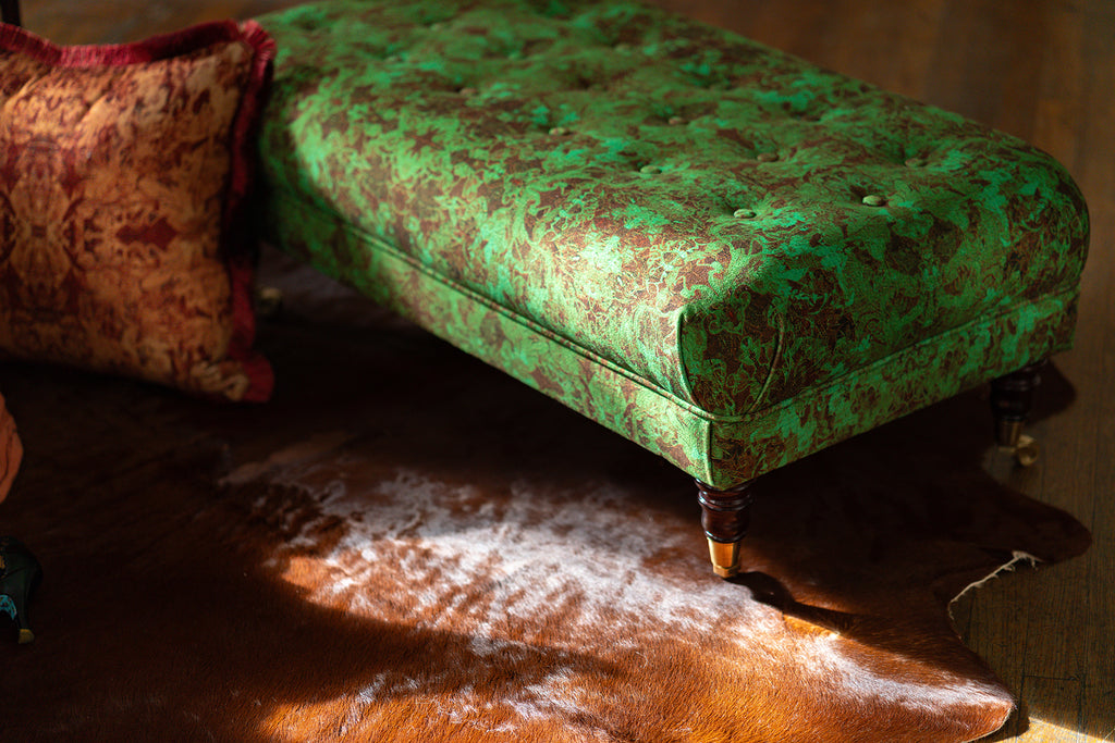 Gatsby green patterned bench on a wooden floor with an pillow.