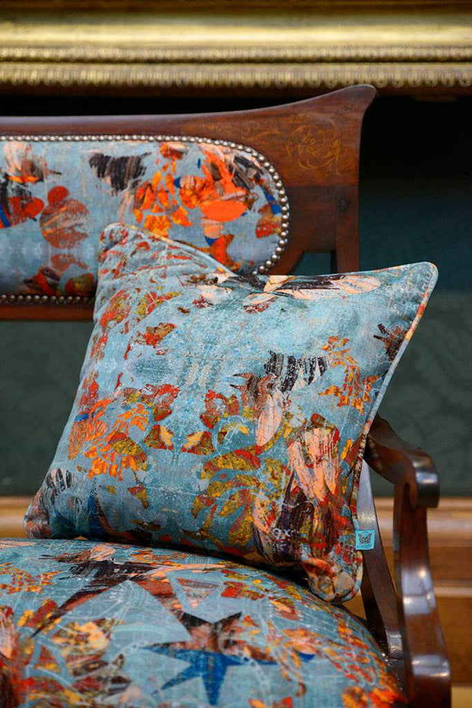 A Mary cushion placed on a Mary upholstered chair in a gallery space interior. 