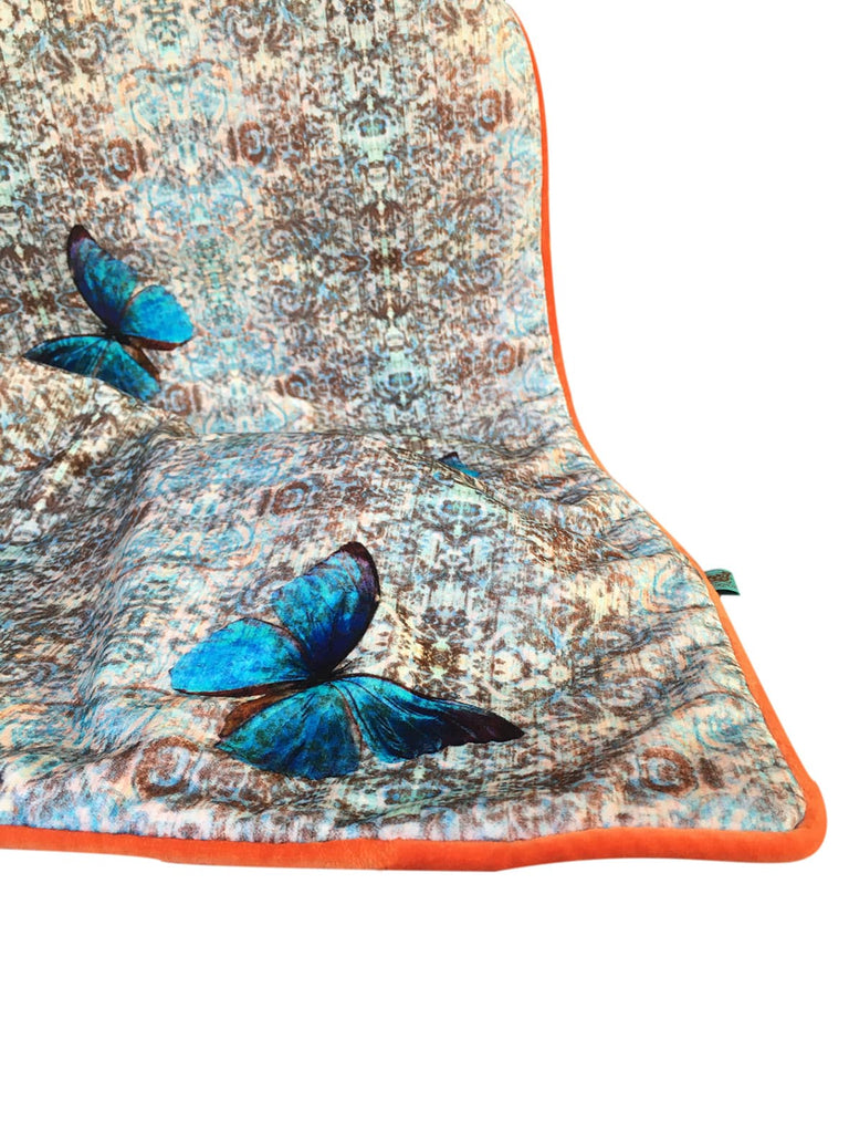 ‘Chapelle Morpho’ velvet bed throw featuring blue damask pattern and orange piping. 