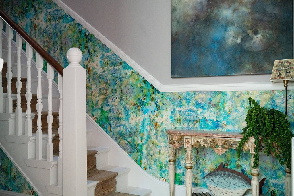 Birdland wallpaper on a staircase wall, paid with a dark wooden banister and white trim. 