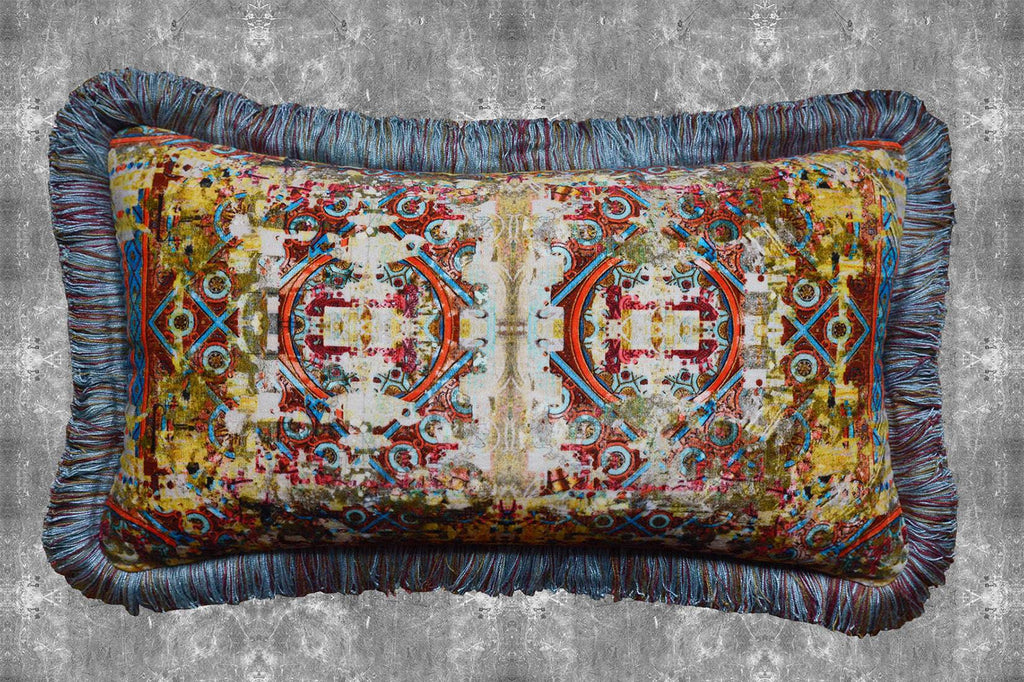 ‘Fresco’ velvet boudoir cushion with fringing featuring yellow, red and blue geometric patterns. 