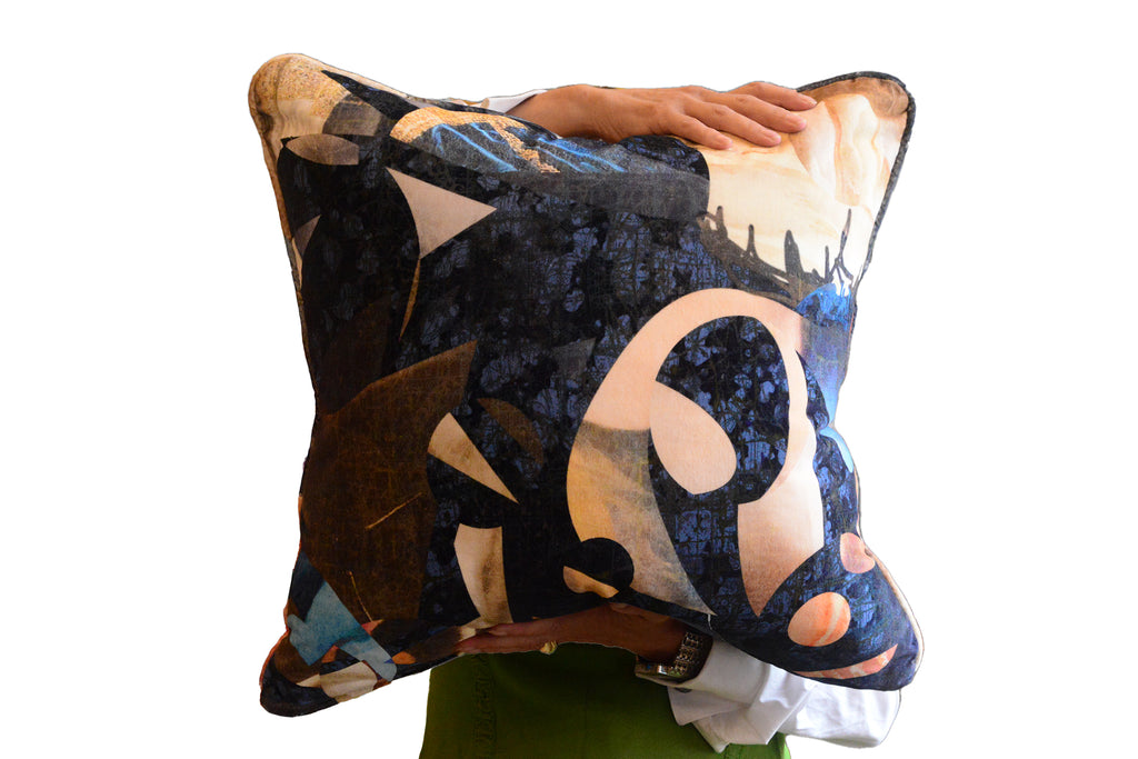 geometric blue cushion being held by a person against a plain background