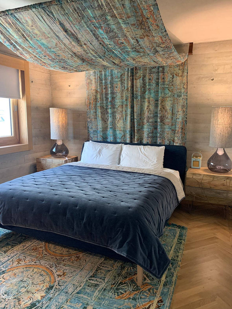 Capriccio fabric used as curtain in elegant, moody bedroom setting 